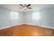 A minimalist bedroom with beautiful hardwood floors and bright windows dressed with white curtains at 3340 Wrenwood Dr, Newton, NC 28658