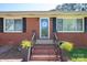 Charming brick house featuring a welcoming front door, well-manicured landscaping, and large windows at 3340 Wrenwood Dr, Newton, NC 28658
