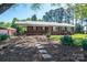 Brick home with a metal roof, porch, and flower beds at 3340 Wrenwood Dr, Newton, NC 28658