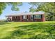 Brick home with a metal roof and front yard with green grass at 3340 Wrenwood Dr, Newton, NC 28658