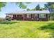 Charming red brick ranch-style home featuring a metal roof and a spacious, well-manicured front lawn at 3340 Wrenwood Dr, Newton, NC 28658