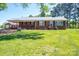 Charming red brick ranch-style home featuring a metal roof and a spacious, well-manicured front lawn at 3340 Wrenwood Dr, Newton, NC 28658