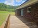 Brick house featuring a wooden deck along the exterior and green grass in the back at 485 Hilltop Rd, Oakboro, NC 28129