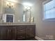 Bathroom featuring a dual sink vanity with granite countertops and modern vanity lighting at 485 Hilltop Rd, Oakboro, NC 28129