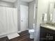 Clean bathroom featuring wood-look floors, single sink vanity, and walk in shower with a curtain at 485 Hilltop Rd, Oakboro, NC 28129