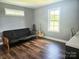 Bedroom featuring a futon, guitar, and natural light from the windows, creating a relaxing space at 485 Hilltop Rd, Oakboro, NC 28129