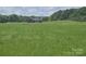Picturesque home with lush green lawn and tree line, offering a serene and private setting at 485 Hilltop Rd, Oakboro, NC 28129