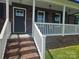 Charming covered porch with brick steps and white railings, creating a welcoming entrance at 485 Hilltop Rd, Oakboro, NC 28129
