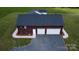 Aerial view of a three-car garage with white doors, a gravel driveway, and a green lawn at 485 Hilltop Rd, Oakboro, NC 28129