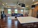 Open-concept living room features a large sectional sofa, wood flooring, and modern ceiling fan at 485 Hilltop Rd, Oakboro, NC 28129