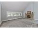 Spacious living room featuring a cozy stone fireplace, large windows, and plush carpeting at 512 Saint Cloud Dr, Statesville, NC 28625