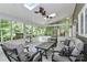Relaxing sunroom featuring comfortable seating, ceiling fan, and a view of the lush greenery at 512 Saint Cloud Dr, Statesville, NC 28625