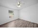 Well-lit bedroom with wood-look flooring, a ceiling fan, and a window creating a comfortable atmosphere at 5318 Austin Rd, Monroe, NC 28112