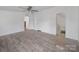 Spacious primary bedroom with wood-look flooring, ceiling fan, ensuite bathroom, and bright natural light at 5318 Austin Rd, Monroe, NC 28112