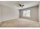 Spacious carpeted bedroom with a ceiling fan and bright natural light at 542 Goldstaff Ln, Charlotte, NC 28273