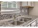 Close-up of the kitchen sink, with granite countertops and mosaic backsplash at 542 Goldstaff Ln, Charlotte, NC 28273