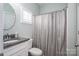 Bathroom featuring a vanity with a granite countertop, framed mirror, and shower with neutral, patterned curtain at 6029 Bountiful St, Belmont, NC 28012
