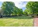 Lush green common area with mature trees and a brick pathway, ideal for outdoor activities and relaxation at 6029 Bountiful St, Belmont, NC 28012