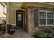 Inviting entrance with a stone facade, decorative door, and potted plants enhancing the curb appeal at 6029 Bountiful St, Belmont, NC 28012