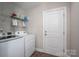 Laundry room with a modern washer and dryer, wire shelving for storage, and an exterior door at 6029 Bountiful St, Belmont, NC 28012