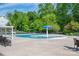 Community pool area featuring comfortable lounge chairs, shade umbrellas, and a playground in the background at 6029 Bountiful St, Belmont, NC 28012