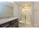 Bright bathroom with granite countertop, dark cabinets, and walk-in shower with glass door at 604 Tudor Park Way, Charlotte, NC 28211