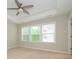 Bright bedroom featuring neutral walls, ceiling fan, and natural light streaming through large windows at 604 Tudor Park Way, Charlotte, NC 28211