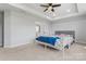 This large primary bedroom has a tray ceiling, carpet, and a view of an open bathroom at 6159 Holland St, Fort Mill, SC 29707