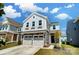 Inviting two-story home with stone accents, attached two-car garage, and manicured front yard with blue sky at 637 Scotch Meadows Loop, Monroe, NC 28110