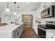 Well-equipped kitchen with white cabinetry, stainless steel appliances, an island with seating, and modern pendant lighting at 637 Scotch Meadows Loop, Monroe, NC 28110