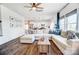 Bright living room with hardwood floors, a large sectional sofa, and views of the modern kitchen at 637 Scotch Meadows Loop, Monroe, NC 28110