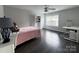 Cozy bedroom with a desk, chair, bookshelf and pink bedspread, illuminated by natural light from a window at 6518 Blackwood Ln, Waxhaw, NC 28173