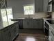 Modern kitchen with gray cabinets, stainless steel appliances, granite countertops, and a breakfast bar area at 6518 Blackwood Ln, Waxhaw, NC 28173