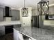 Spacious kitchen with stainless steel appliances, granite countertops, gray cabinetry, and modern pendant lighting at 6518 Blackwood Ln, Waxhaw, NC 28173