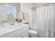 Bathroom featuring a vanity with white cabinets, large mirror, and a shower-tub combo with patterned curtains at 660 Daventry Ct # 35, Clover, SC 29710