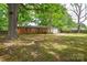 View of the backyard with lawn and partial view of the brick home and trees at 7224 Kuck Rd, Mint Hill, NC 28227