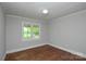 A bedroom with hardwood floors, a window, and a light fixture at 7224 Kuck Rd, Mint Hill, NC 28227