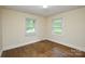 Bedroom with hardwood floors, two windows, and neutral paint at 7224 Kuck Rd, Mint Hill, NC 28227