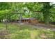 A charming brick home with mature trees and well-maintained lawn and gravel driveway at 7224 Kuck Rd, Mint Hill, NC 28227
