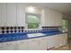 A bright kitchen featuring white cabinets and eye-catching blue tile backsplash at 7224 Kuck Rd, Mint Hill, NC 28227