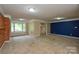 Spacious living room featuring a brick wall, large windows, and neutral carpeting at 7224 Kuck Rd, Mint Hill, NC 28227