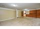 Large living room area with view of kitchen, brick wall, and multiple entrances at 7224 Kuck Rd, Mint Hill, NC 28227