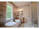 This bathroom contains wood accent walls, a soaking tub, and a glass shower at 724 Ideal Way, Charlotte, NC 28203