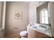 This half bathroom has a tiled accent wall, and a modern, rectangular sink with brushed bronze fixtures at 724 Ideal Way, Charlotte, NC 28203