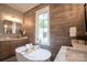 This bathroom is designed with modern décor, soaker tub, and a light wood accent wall at 724 Ideal Way, Charlotte, NC 28203