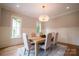 This dining room boasts a decorative chandelier, windows, and seating for six around a light wood table at 724 Ideal Way, Charlotte, NC 28203