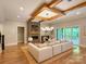 Open-concept living area with fireplace, wood beams, hardwood floors, and seamless flow to outdoor living space at 724 Ideal Way, Charlotte, NC 28203