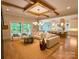 Bright open-concept living room with wood beams, hardwood floors, and seamless flow to kitchen and outdoor deck at 724 Ideal Way, Charlotte, NC 28203