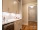 Beautiful wet bar with white cabinets, wine fridge, marble countertop, and gold hardware at 724 Ideal Way, Charlotte, NC 28203