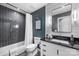 Modern bathroom with tile backsplash, shower/tub combo, and sleek vanity with black countertop at 742 Lansdowne Rd, Charlotte, NC 28270